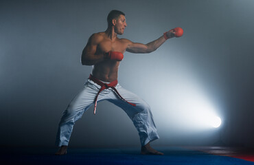 One judoka fighter man in kimono practicing in the gym