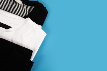 Classic Black and white t-shirts on a blue background, copy space