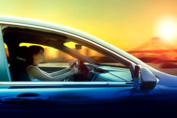 woman driving a car against city skyline with beautiful sunset