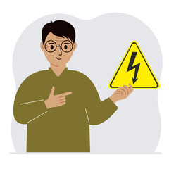 A man holds a yellow triangular warning sign with a black lightning in his hand. The concept of the danger of electric shock or high voltage.