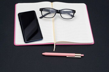 Diary, mobile phone, pen and glasses as a concept for keeping a diary, retirement planning and household chores