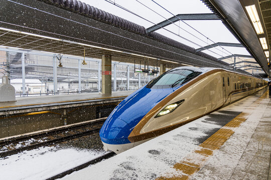 雪の舞う長野駅のホームに入る北陸新幹線