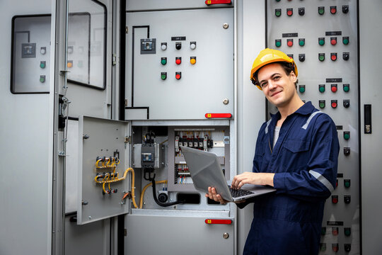 Electrical engineer working in control room. Electrical engineer man checking Power Distribution Cabinet in the control room