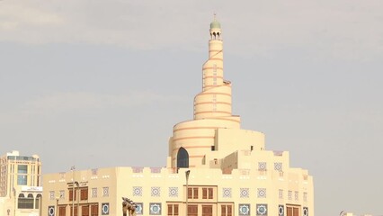 Doha, Qatar - April, 27, 2023: Doha Fanar Mosque.
Pigeons have been accustomed to congregate within a specific area in the Souq Waqif square in front of the mosque, where grain is scattered to feed it