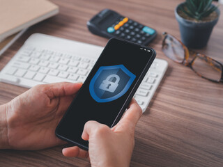 Personal information security concept. Shield icon and padlock on user smartphone screen authentication before privacy login. Security of personal information and data protection..