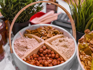 Raw Organic Ground Hazelnut Flour in a Bowl with whole nuts. Alternative nut flour for keto diet and gluten free food. Paleo and ketogenic diet baking cooking concept.