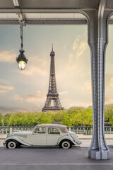 Paris, France. Eiffel Tower with Vintage French car at sunset photographed from Bir Hakeim Bridge. Iconic view and landscape in Europe
