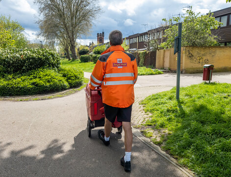 London. UK-04.28.2023. A Royal Mail postman doing his rounds on house to house postal delivery.