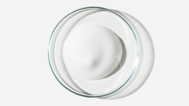 Foam, foam texture. Washing with foam. Foam in a Petri dish on a light background. Dab of cosmetic foam. Lab.