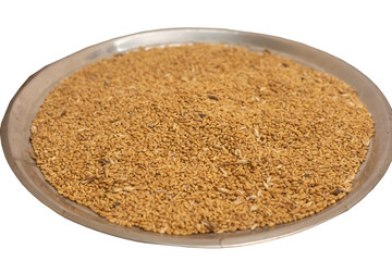 Organic wheat seeds on silver plate. Close-up view. Selective focus.