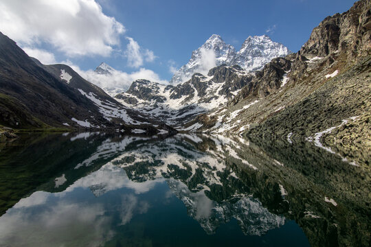 il monviso ancora innevato si specchia nelle acque del lago fiorenza