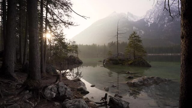 Sun peaking through th trees at Hintersee Lake in . Ramsau, Berchtesgaden, Bavaria, Germany, Europe