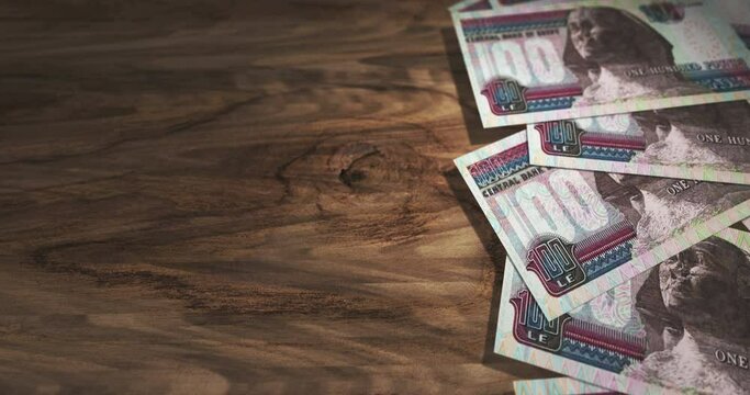 Egyptian Pound 100 EGP banknotes on the wooden table. Egypt currency paper notes 3D concept background. Seamless and looped.
