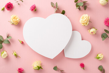 Nature never looked so beautiful! This top view flat lay showcases roses and eucalyptus on a pastel pink background. The two empty hearts are perfect for branding or messaging