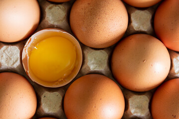 Chicken eggs lie in a tray on the kitchen surface with a broken yellow yolk. Buying products and...