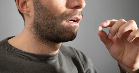 Man taking medicine pill at home.