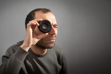 Man looking through camera lens.