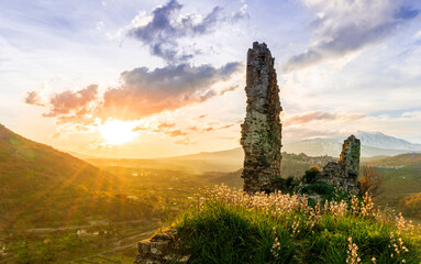 beautiful medieval castle ruins on mountain during nice sunset or sunrise with highland landscape...