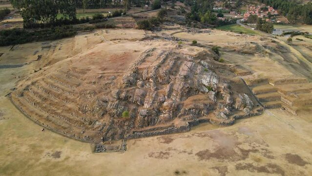 4K Aerial Drone pull back from Rodadero Rock Formation at Sacsayhuaman in Cusco, Peru. Camera tilts up. Ancient Incan ruins visible