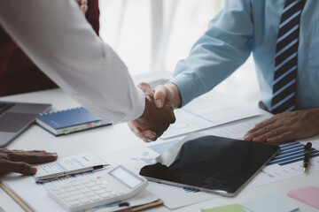 Business investor group shakes hands, Two businessmen are agreeing on business together and shaking hands after a successful negotiation. Handshaking is a Western greeting or congratulation.