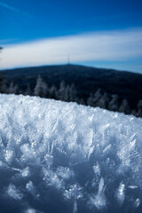 Schnee und Eiskristalle mit Struktur und einem Berg im Hintergrund.