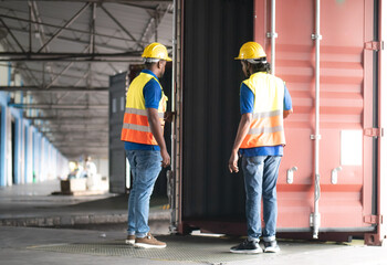 Foreman team standing at shipping warehouse checking cargo loading into export container. Industrial engineer working with supervisor inspecting transport shipment for international commercial trade.