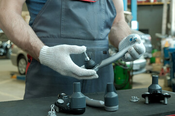 Repair and maintenance of the car. The car mechanic holds the steering tip to control the...