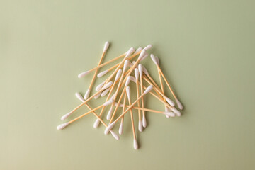 Flat plan of white cotton ear buds on green background with copy space. Concept of hygiene, medicine, health care, beauty