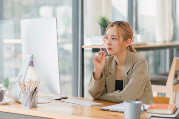 A focused and professional millennial Asian graphic designer, woman working on computer and deep in...