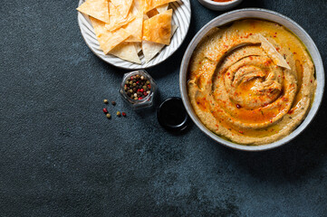 Traditional arabian eggplant dip baba ganoush with herbs and smoked paprika on dark background. Eggplant hummus. Babaganush or eggplant caviar. Baked eggplant. Turkish eggplant dip