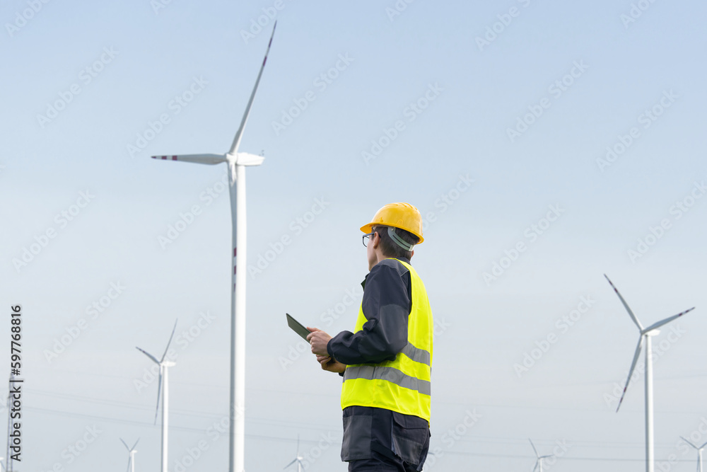 Poster Engineer with tablet computer on a background of wind turbines	