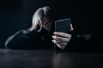 Young teenager female girl with smartphone felling lonely and hopeless. Online bullying and...