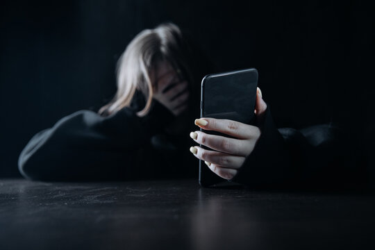 Young teenager female girl with smartphone felling lonely and hopeless. Online bullying and harassment concept