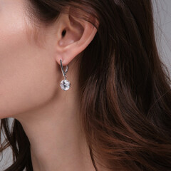 Woman Jewelery concept. Woman hands close up wearing rings, earrings.