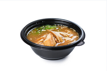 Soup with seafood in a disposable plate on a white background. Food delivery concept