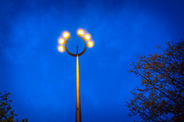 Lighted street safety lamps in the air against the blue sky at dawn at the Place Bellecour plaza in...
