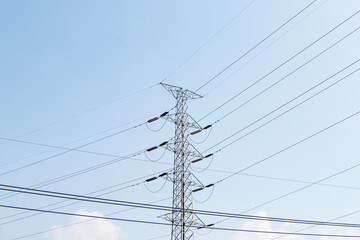 High voltage post or transmission towers in nature day light. High-voltage tower. Electricity is basic of each country. Bright blue sky with bright sunlight background. Huge source of electric power.