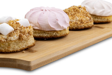 Cakes on a wooden board on white, close-up, selective focus