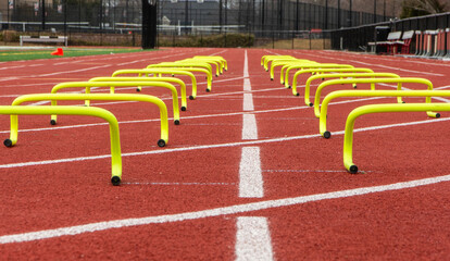 Close up view of small yellow hurdles in two lanes on a track