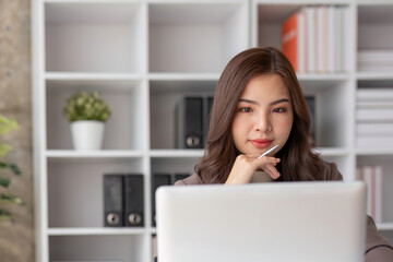 Fototapeta premium Close up Business woman using calculator and laptop for do math finance on wooden desk in office and business working background, tax, accounting, statistics and analytic research concept.