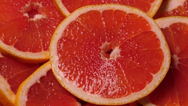 Grapefruit slices rotating. Closeup fruit background. Nobody