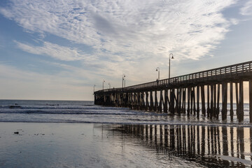 Fototapeta premium A view on the pier on the Pacific coast at sunset