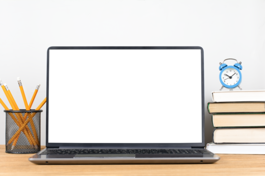 Modern workplace, laptop with blank transparent screen, stack of books, alarm clock and pencil pot on the desk
