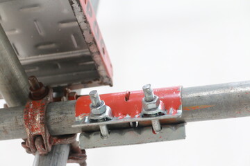 Scaffolding pipe clamp. Steel scaffolding and mounting parts for strength in construction sites . Close-up and select focus	 - 597799813