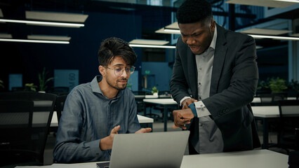 Fototapeta premium Annoyed furious african businessman shout on arabian worker angry man boss scolding young employee for bad computer result multiracial men has conflict dispute problem business people argue in office