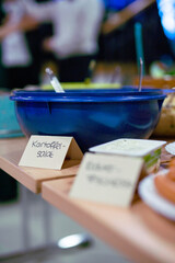 Schüssel mit Schild und Kartoffelsalat auf einem Buffet