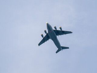 Four-engine military aircraft flying in light blue sky