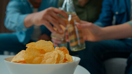 Multiracial friends men women watching television at home young hispanic couple relax on couch african man with wife sit on floor enjoy TV comedy film. Diverse ethnic people laughing rest with beer