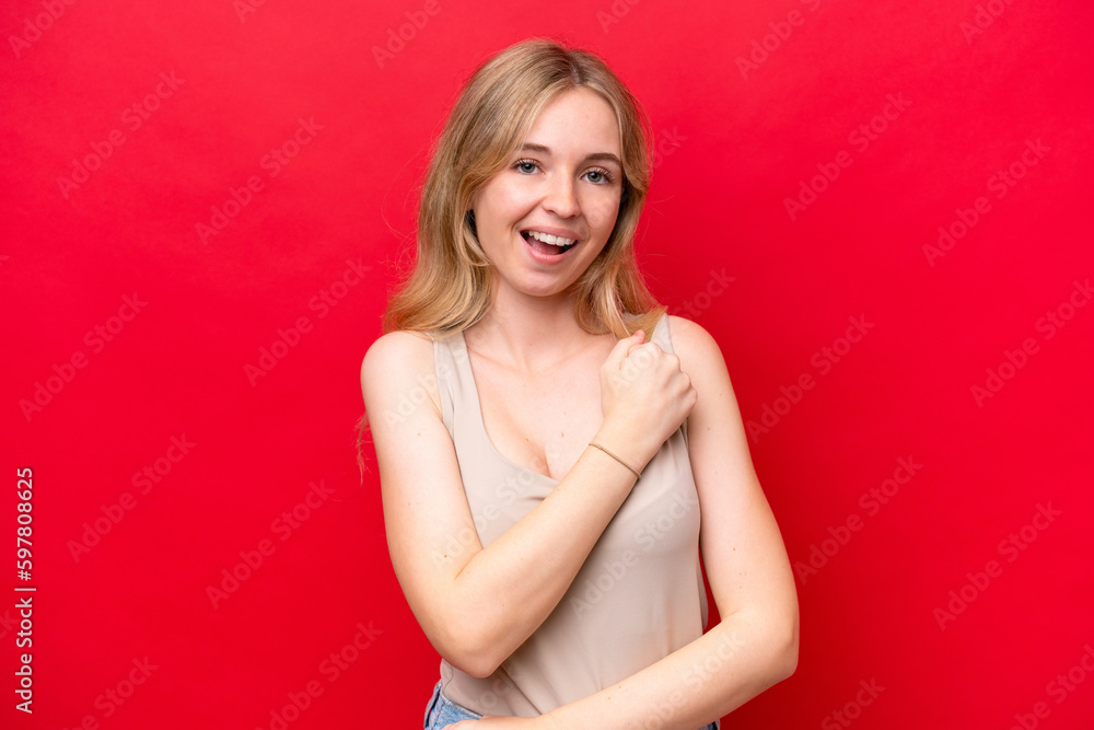 Wall mural Young English woman isolated on red background celebrating a victory