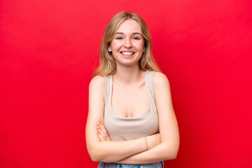 Young English woman isolated on red background keeping the arms crossed in frontal position